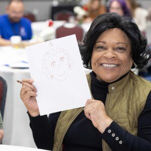 Woman holds up drawing at CASA Strong Conference