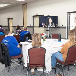 Group of volunteers watch screen showing speaker at CASA Strong Conference